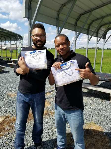 Young man and stepdad hold certificates up as stepdad legally adopts wife's son