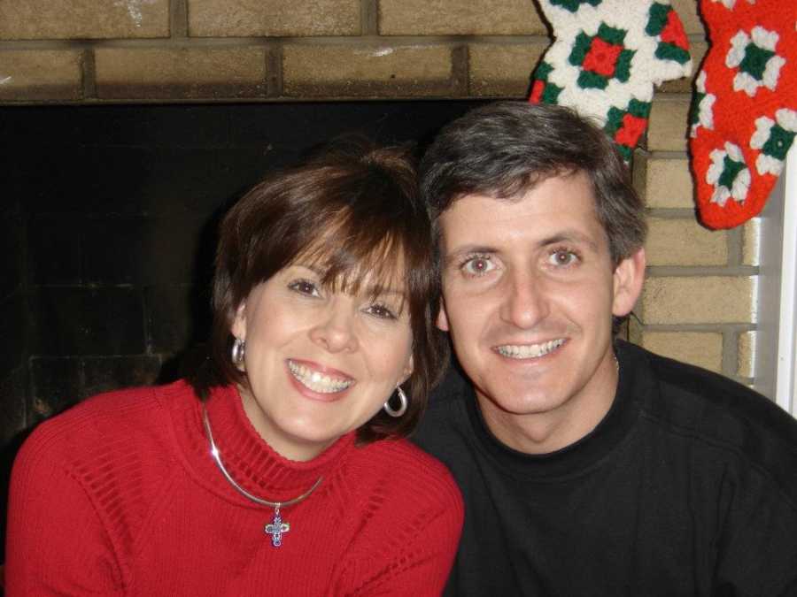 Husband and wife smile by fireplace before wife was hit by car and suffered memory loss