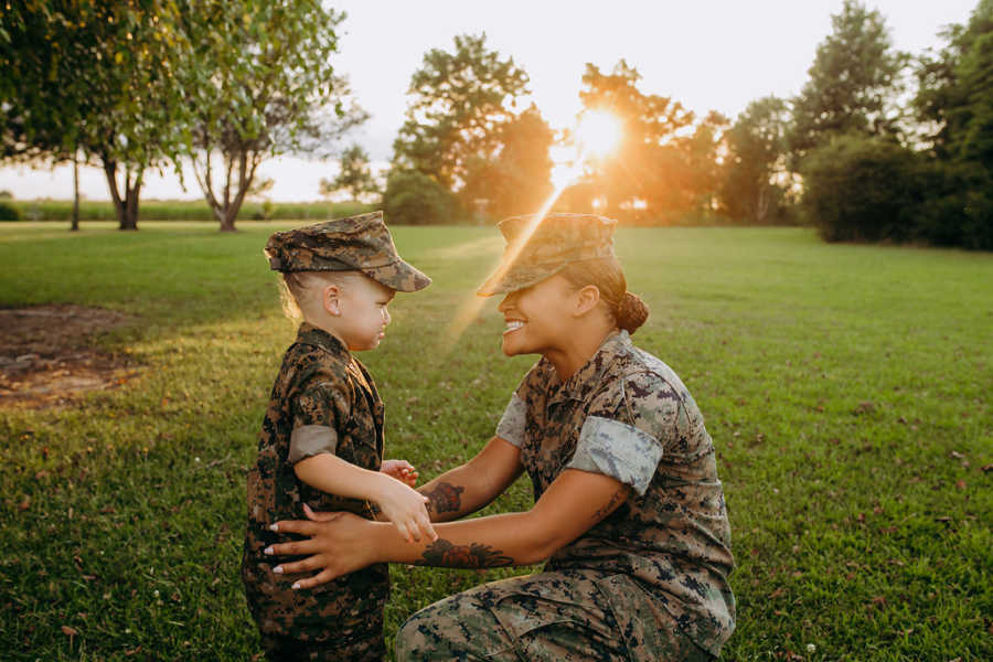 Little girl cries while hugging her marine mom in matching uniforms