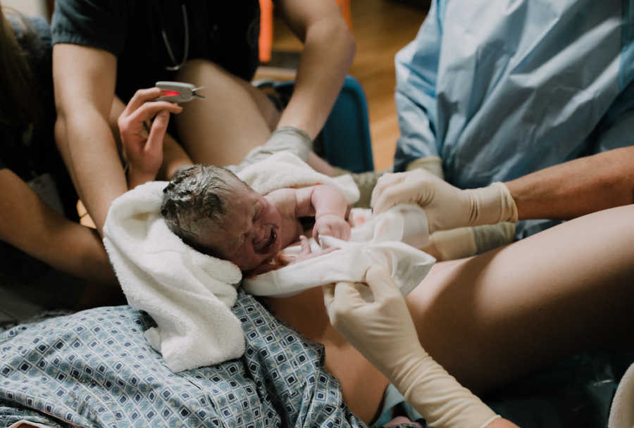 Nurses pass newborn baby to their mother after 11 hours of labor