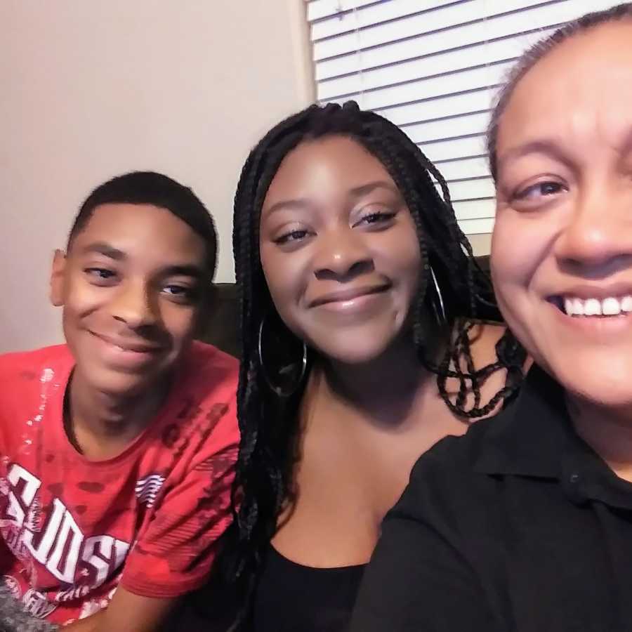 Mother smiles in selfie with teen daughter and son who she is proud of