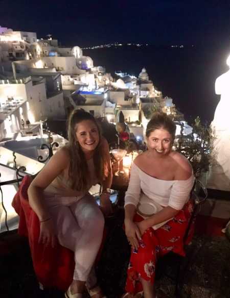 Woman and friend take a photo together while enjoying vacation in Greece