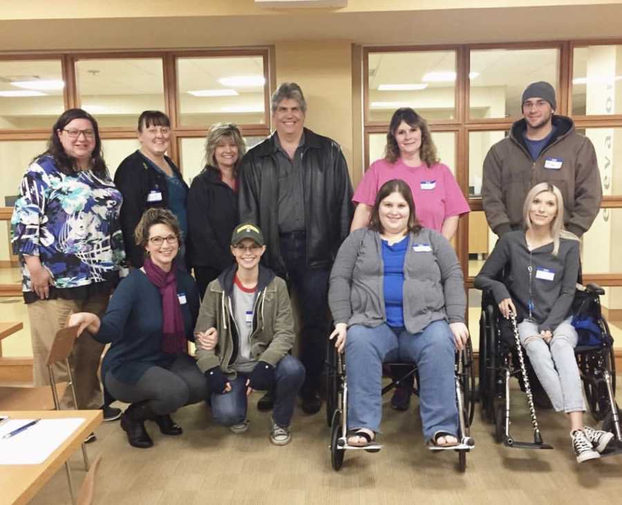 Woman with Ehlers-Danlos Syndrome sits in wheel chair with her peers in support group