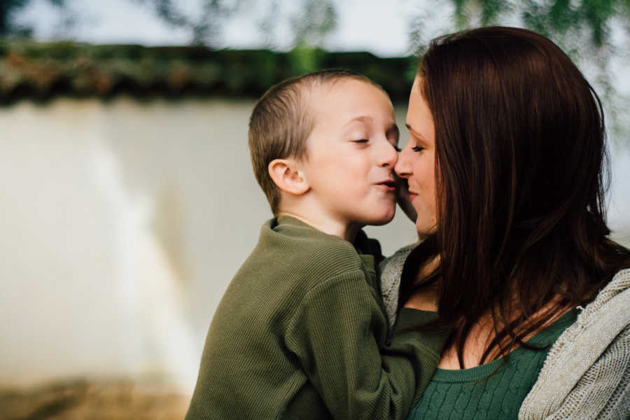 Mother holds and is close to kissing son she had when she was seventeen