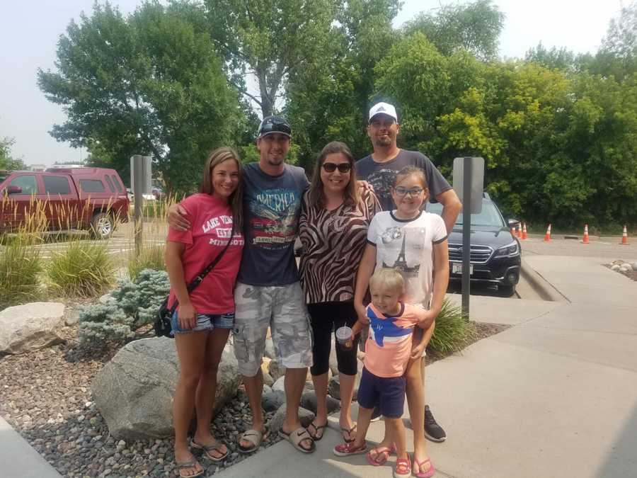 Brother stands with wife and sister who was put up for adoption and her family