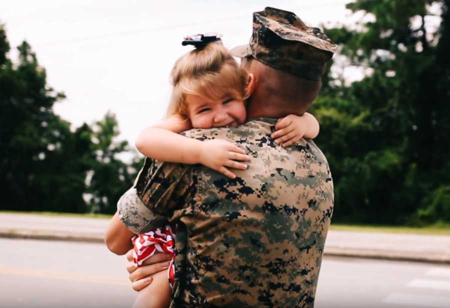 Little girl has big smile on her face as she hugs her soldier father who just returned home