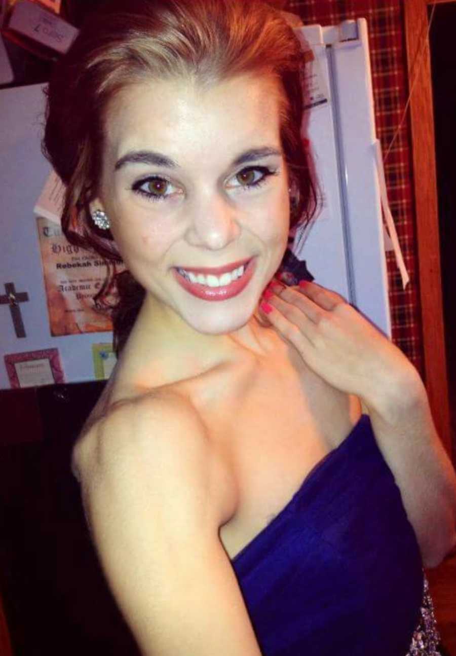 Woman smiles big for a photo with her collarbones and shoulder bones protruding