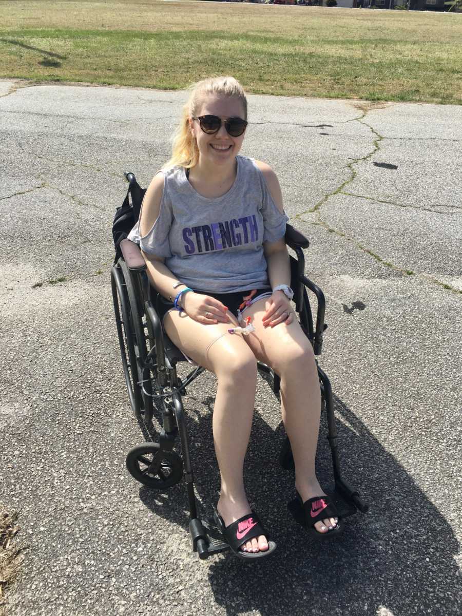 Teen with Dysautonomia sits smiling in wheelchair 