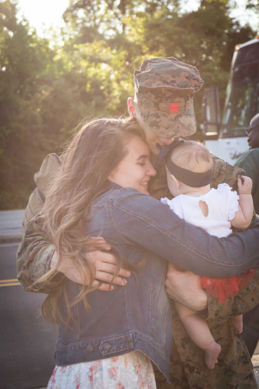 Soldier hugs wife and baby daughter as he leaves for deployment