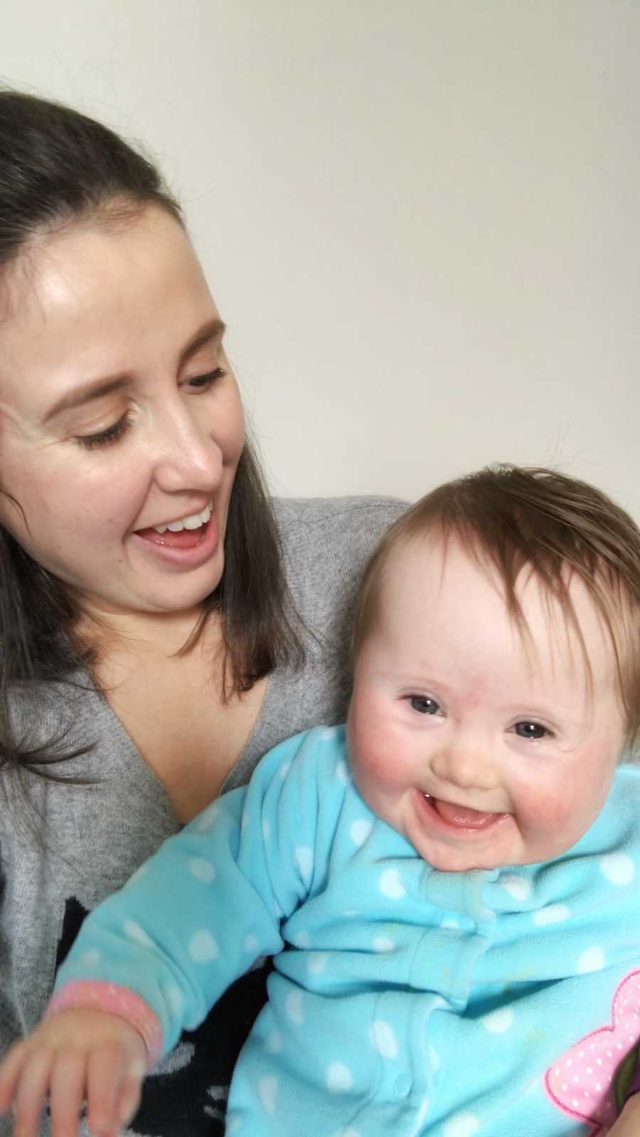 Woman who struggled to get pregnant smiles at one of her twins who has down syndrome
