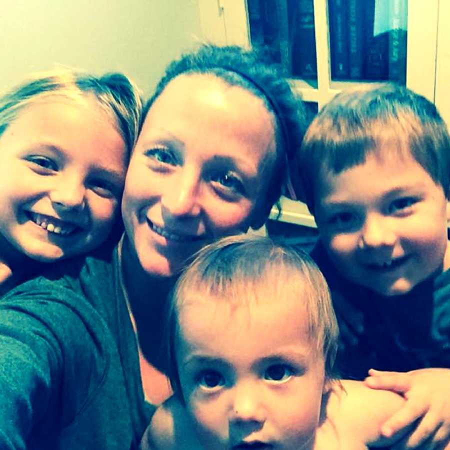Mother who wonders what it would be like to not be one for a day smiles in selfie with three young children