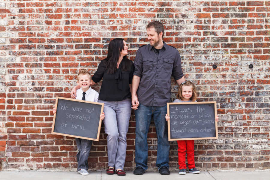 Woman who isn't able to have kids stands with husband beside their adopted son and daughter
