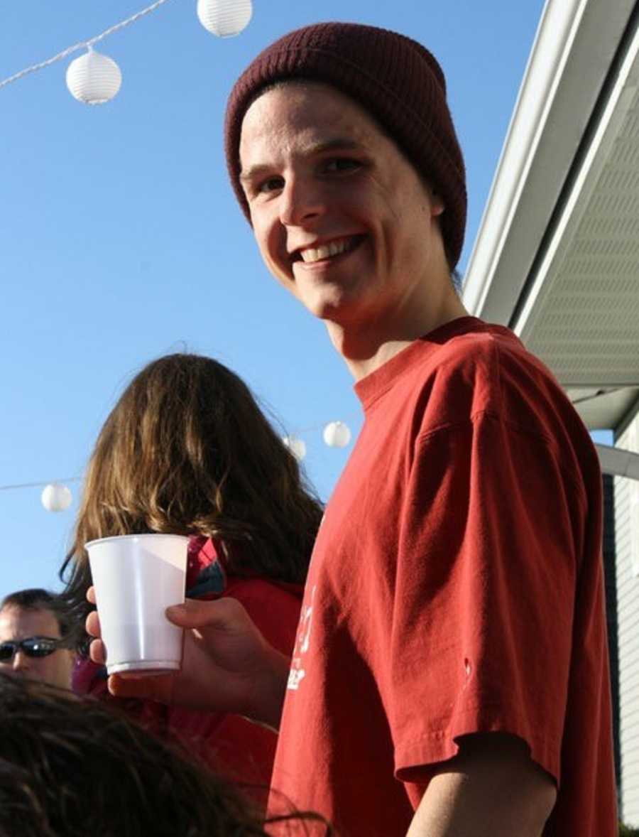 Drug addict smiling while holding clear plastic cup