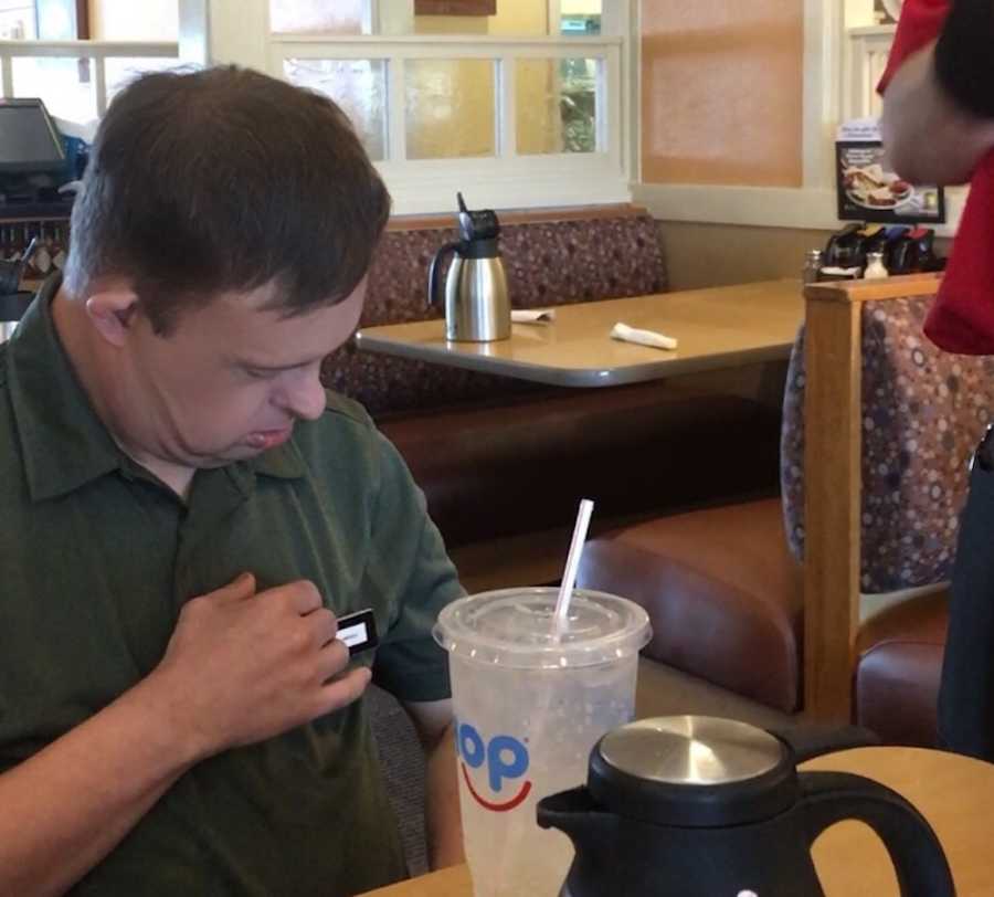 50 year old man with down syndrome looking at Captain America pin waitress pinned on him