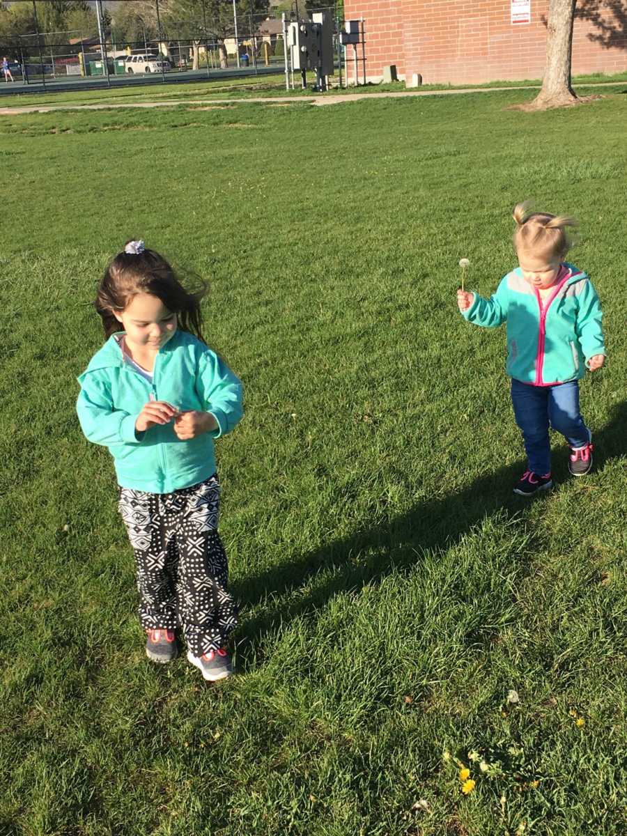 Toddlers whose mother has nightmares about her kids stand in grass