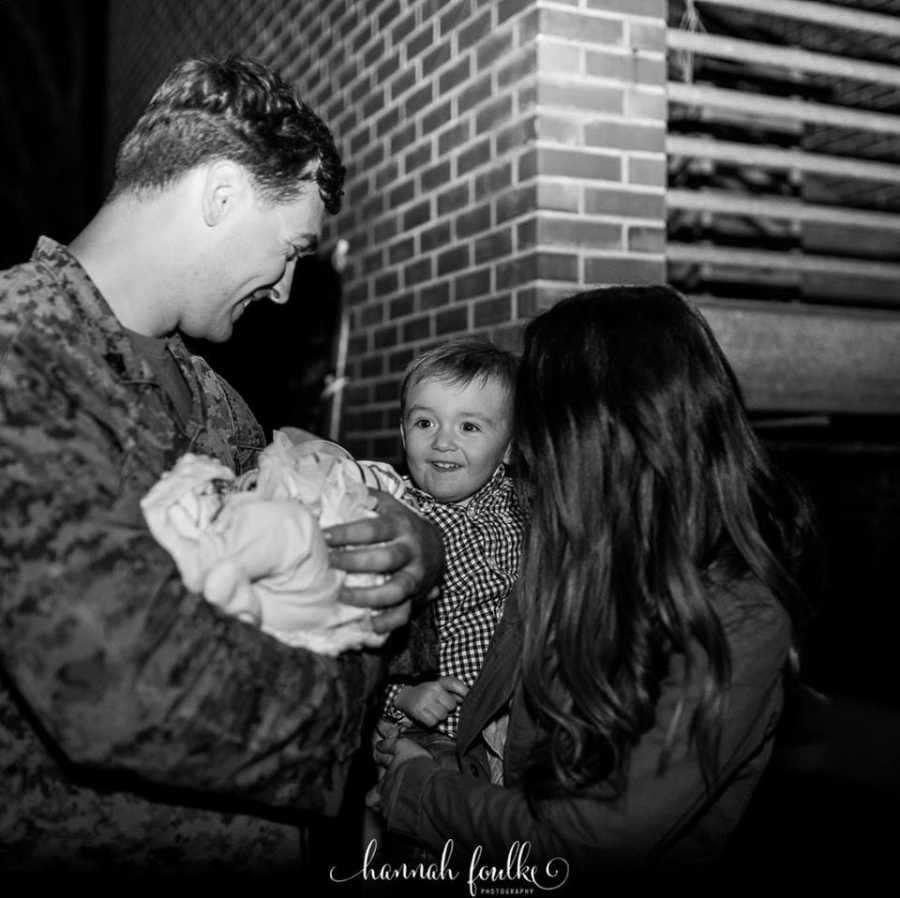 Family of four take newborn photos together with their newborn daughter while dad wears his Marines uniform