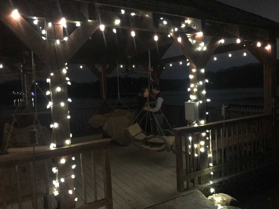 Man proposing under gazebo with twinkly lights on it