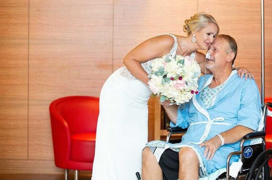 Bride leans over to hug father in wheelchair who is in hospital with pancreatitis