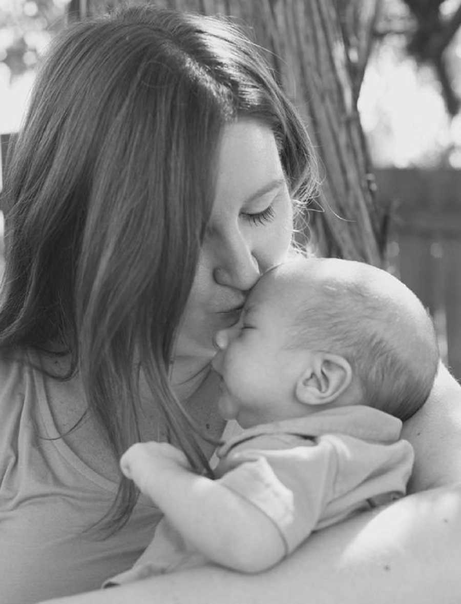 Mother who didn't know what motherhood was like holds newborn and kisses him on head