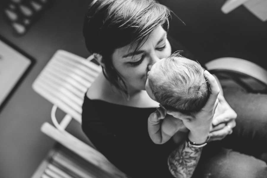 Mother of 3 kisses her foster baby that she holds in her hand