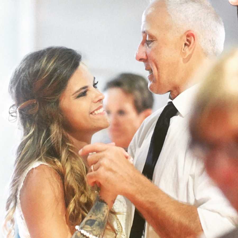 Bride smiles while dancing with father who got a tattoo for her