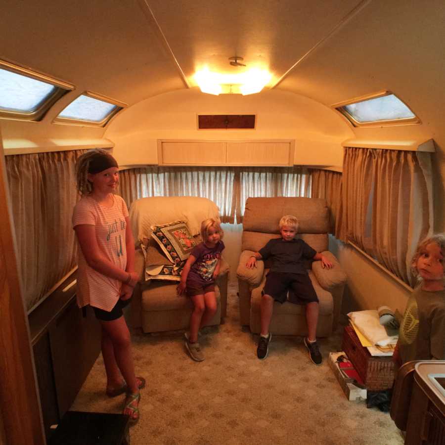 Four children sit in airstream which is their new home