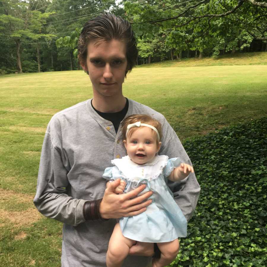 Young uncle holds his niece while spending outside time together
