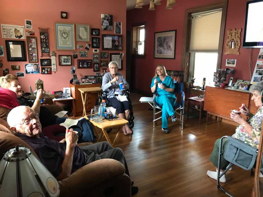 Daughter of woman with dementia sits with her father mother and their two friends as they eat Dairy Queen Blizzards at home