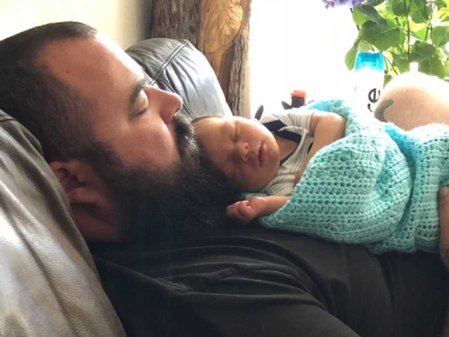 Father lies asleep with newborn asleep on his chest