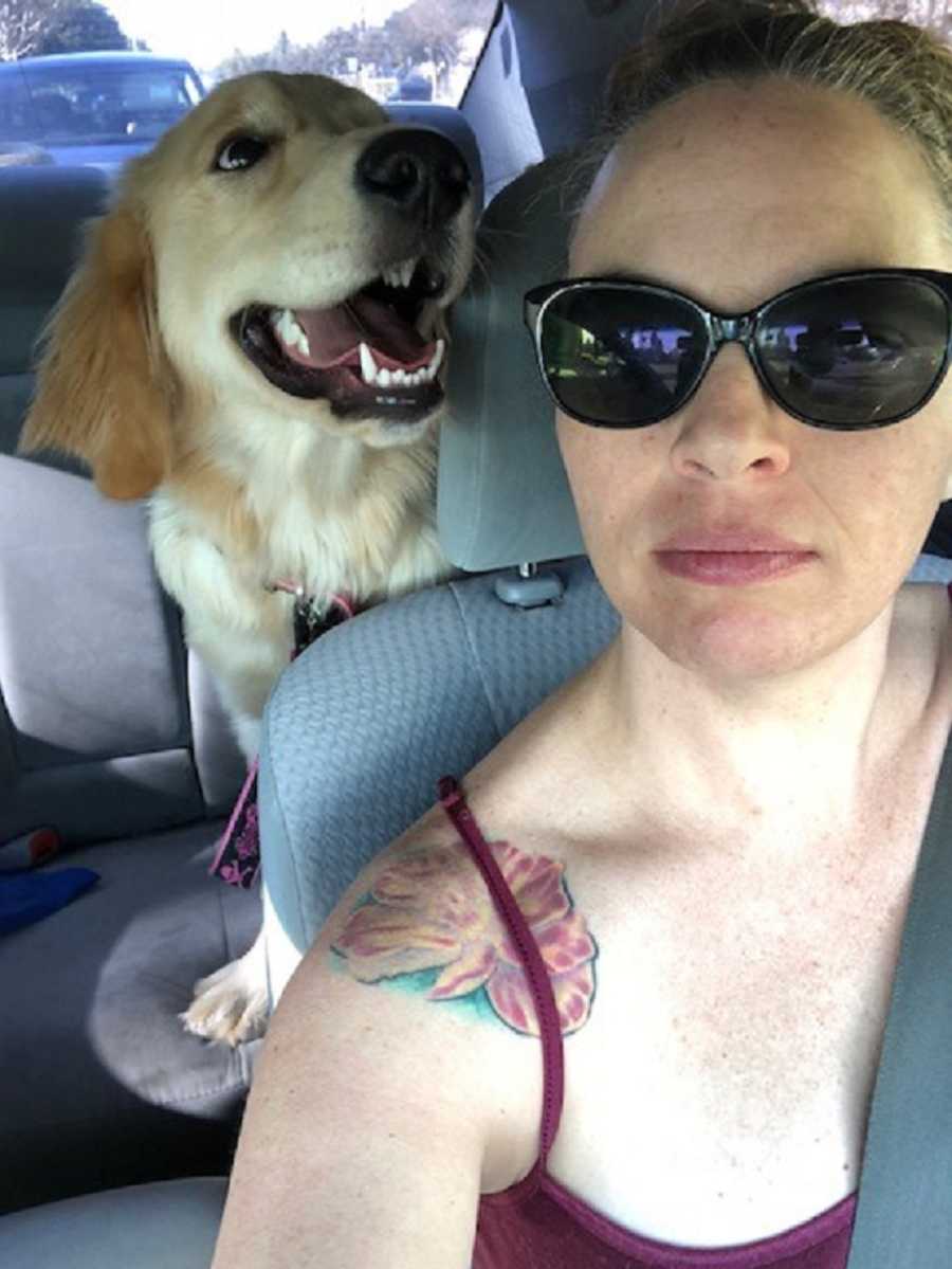 Woman who had hard time conceiving takes selfie in car with her dog in back seat