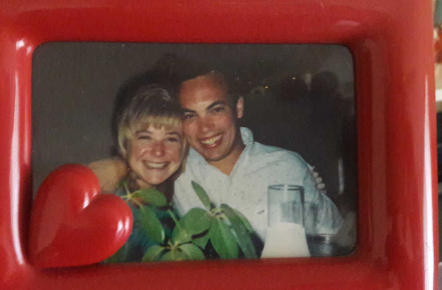 Man smiling in picture frame with wife who passed away 28 years ago