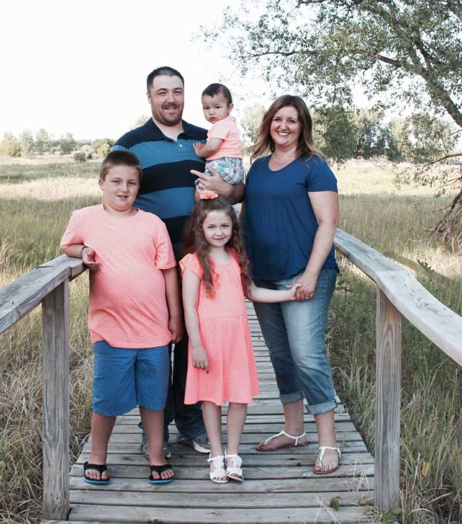 Family of five take photos together in blue and peach colors