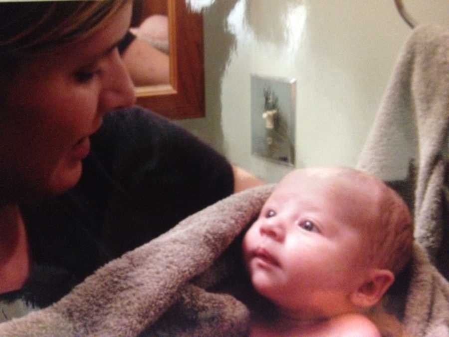 Woman who isn't able to have kids holds newborn baby in towel whom she is fostering