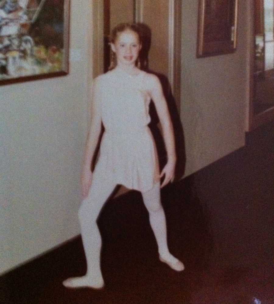 Young girl who would have hysterectomy stands in ballet position with ballet clothes on 