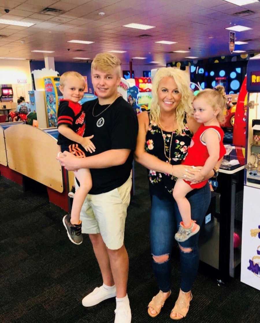 Recovered junkie stands in arcade with son she had as teen and her twin toddlers