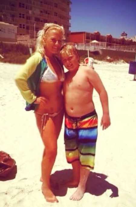 Young mother stands on beach with son she had as a teen