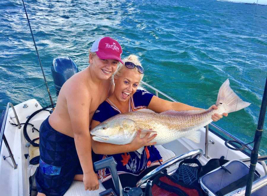 Recovered junkie holds large fish on boat with son