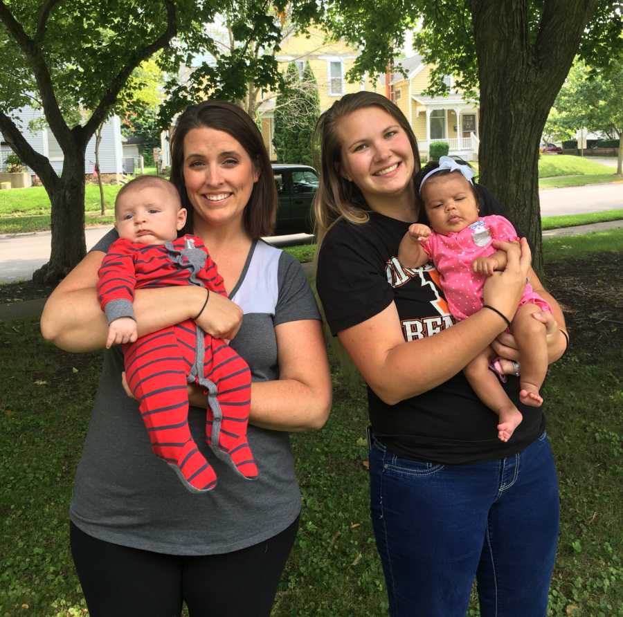 Woman who donates breast milk stands with her daughter beside woman who receives her milk with her son