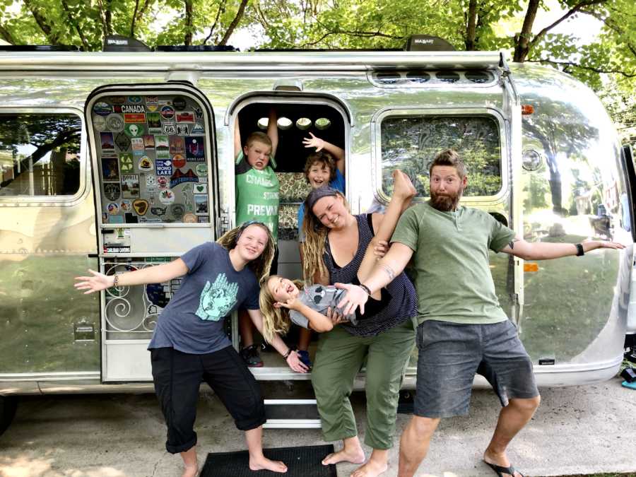 Family of six pose in front of airstream that is now their home that they travel the country in