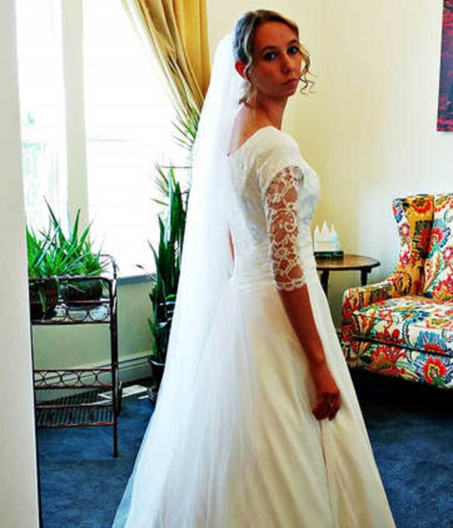 Woman stands in wedding gown who will realize her fiancee was unfaithful