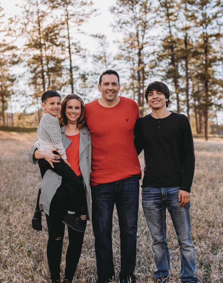 Mother holds son next to husband and stepson who she has a hard time sending off to college