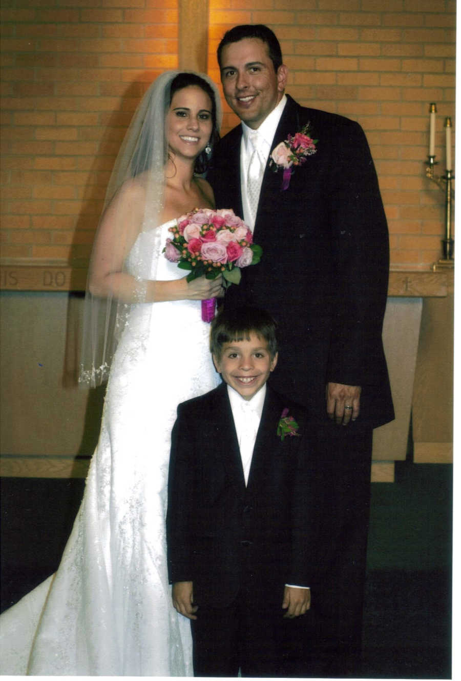 Bride and groom on wedding day with husband's son 