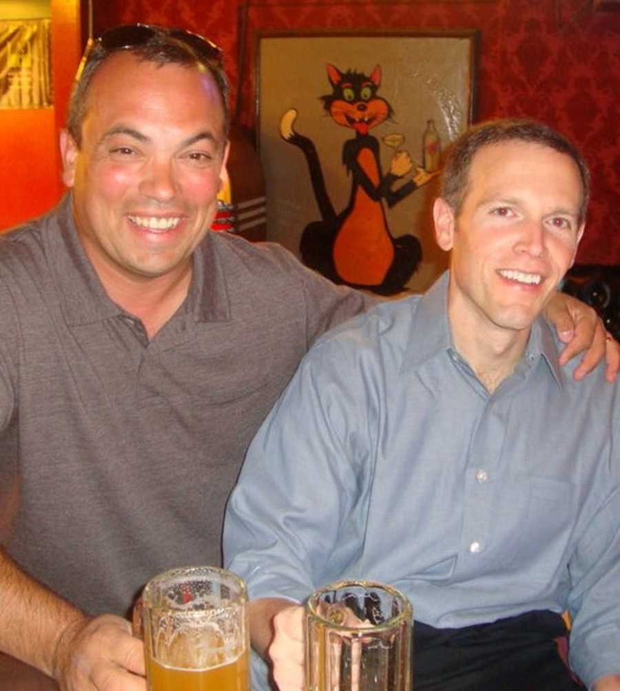 Childhood friends smiling in bars holding beer mugs