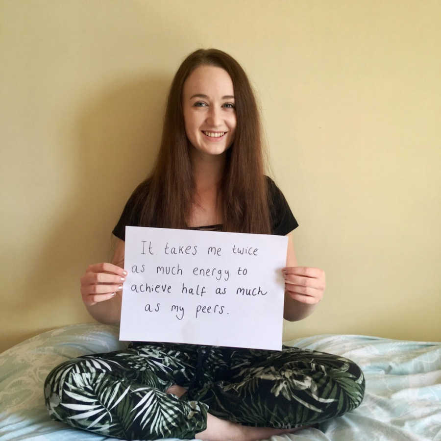 Young woman holds sign that says, "It takes me twice as much energy to achieve half as much as my peers"