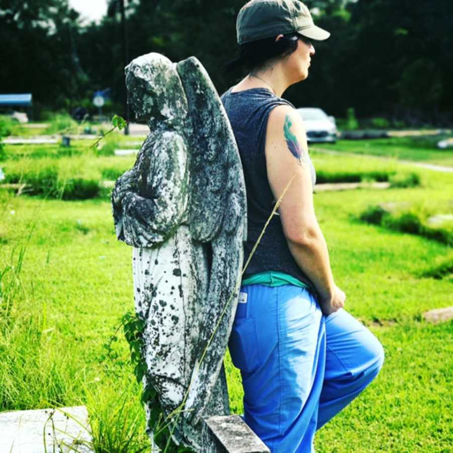 Woman who once attempted suicide stands back to back with stone angel statue