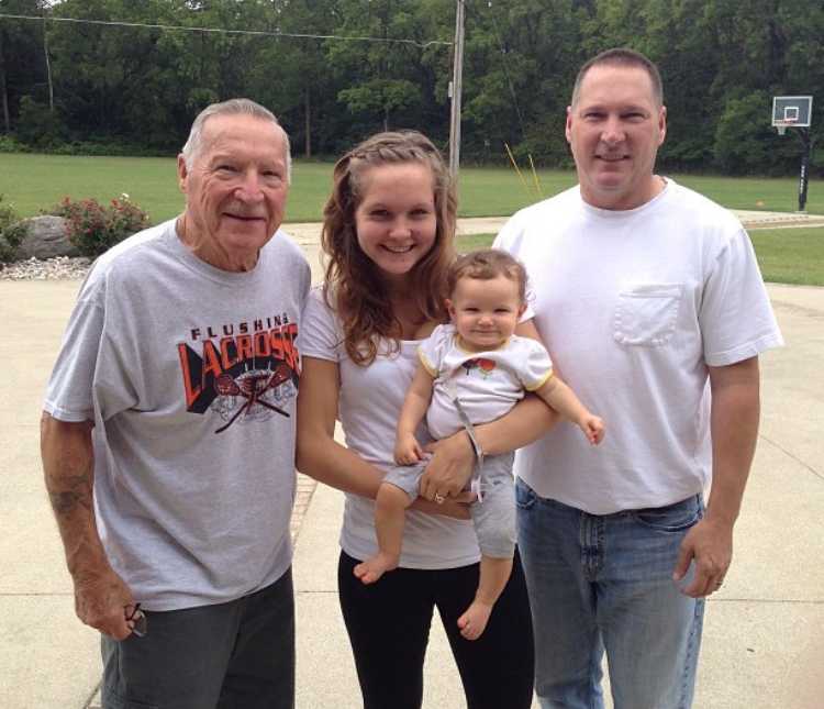 Woman holding her baby beside her grandpa and father who has since passed away