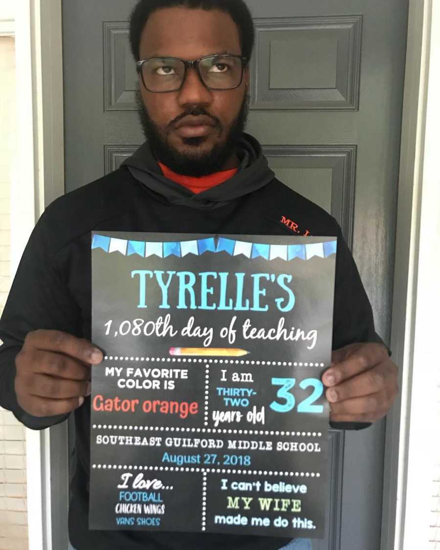 Teacher holds up sign saying, "Tyrelle's 1,080 day of teaching"