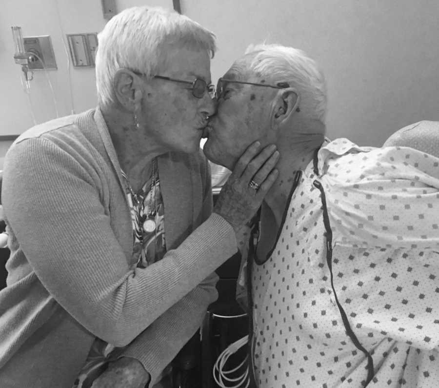 Woman with dementia kisses husband on the lips who is on hospital gown
