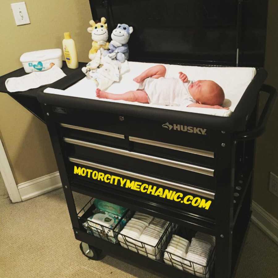 Newborn lying on changing table which is really a tool cart father transformed into changing station