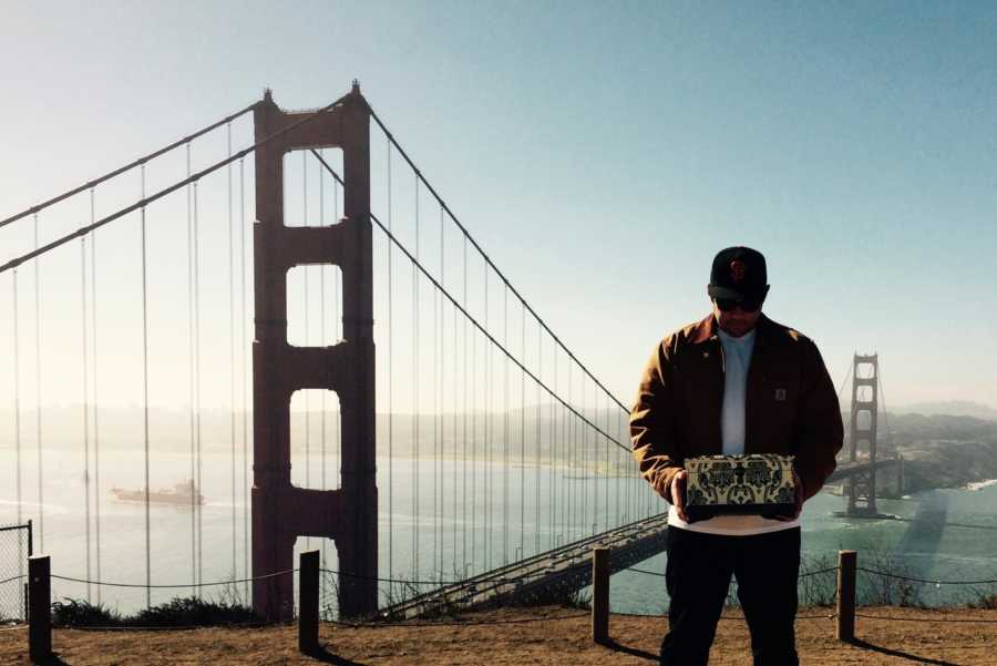 Man stands on cliff beside Golden Gate Bridge holding deceased wife's ashes